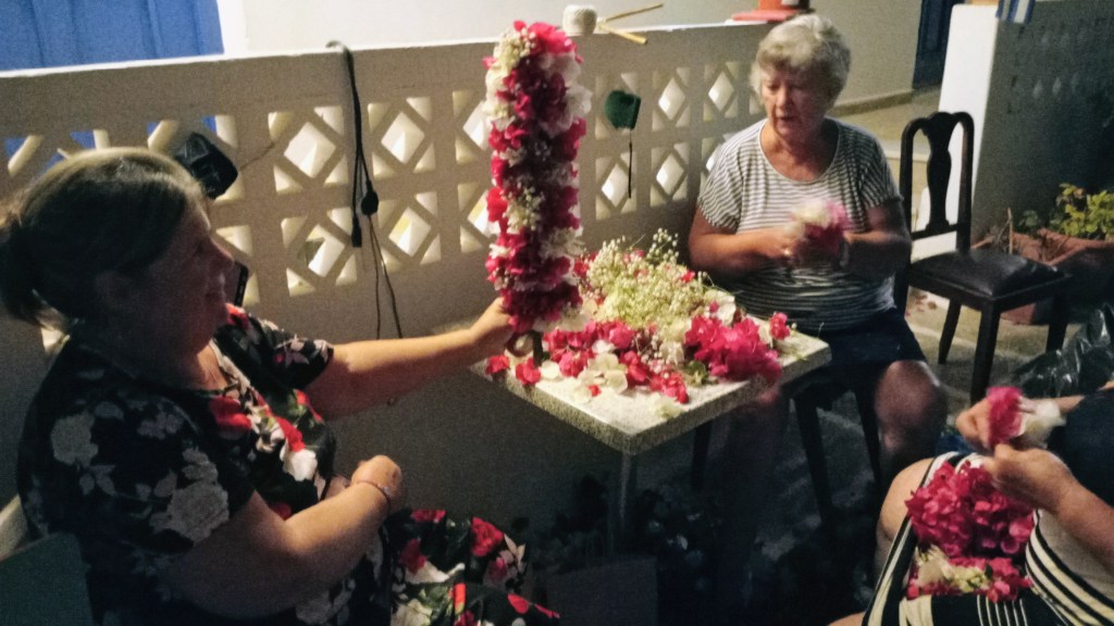 Women making crosses from flowers