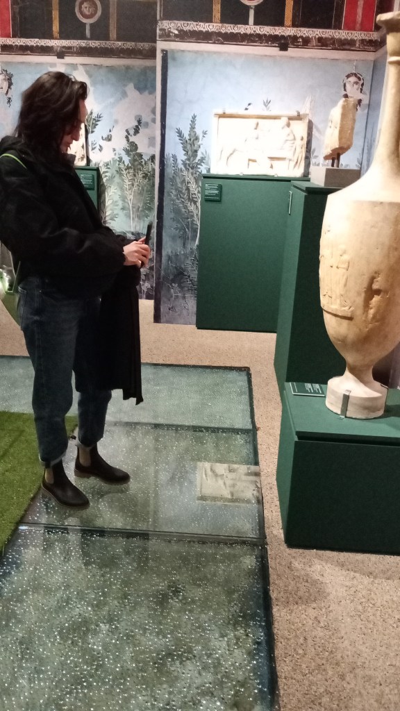woman in a room with wall paintings and marble objects