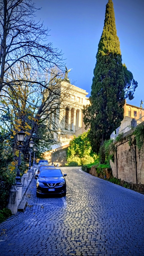 foto of a road going up a slop with il Vittoriano in the background