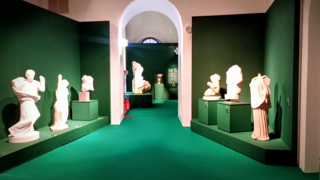 room with green walls and lost of statues