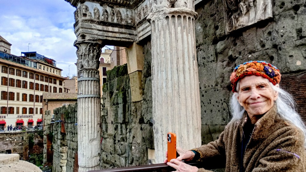 woman holding a camera in fron of two columns