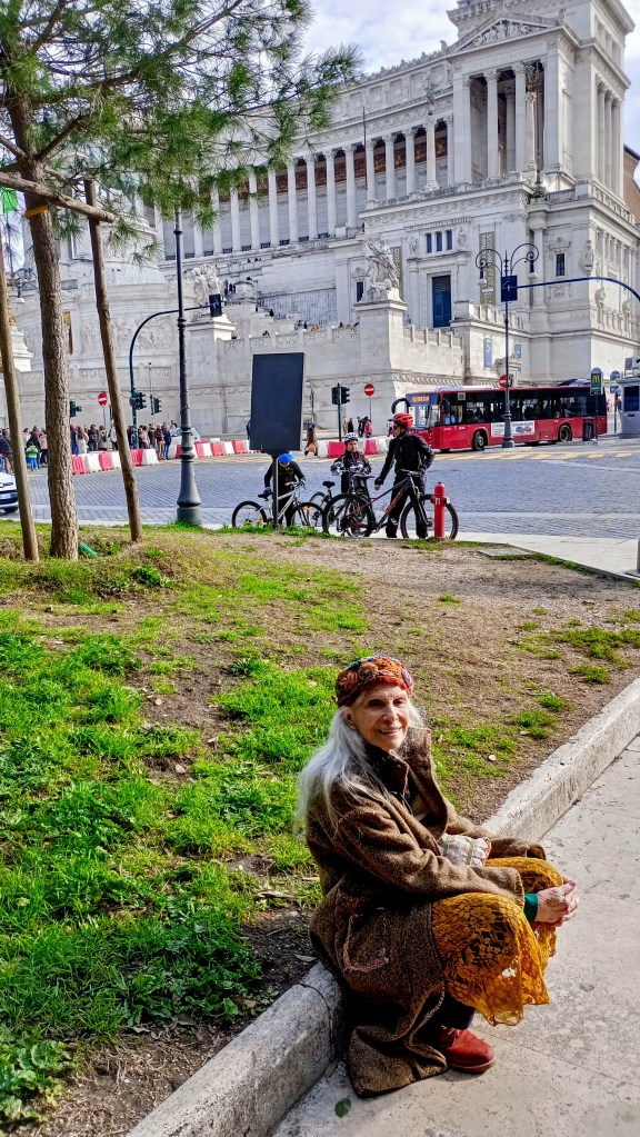 the altare della Patria big white structure
woman wearinghat sitting on the ground