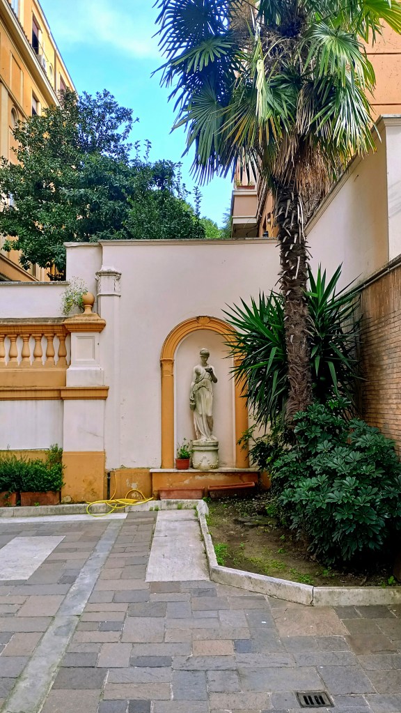 photography of a driveway with a niche sheltering a statue of Venus