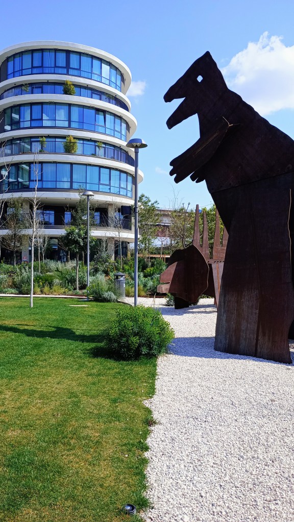 photo of a building with many windows and a nearby dinosaur