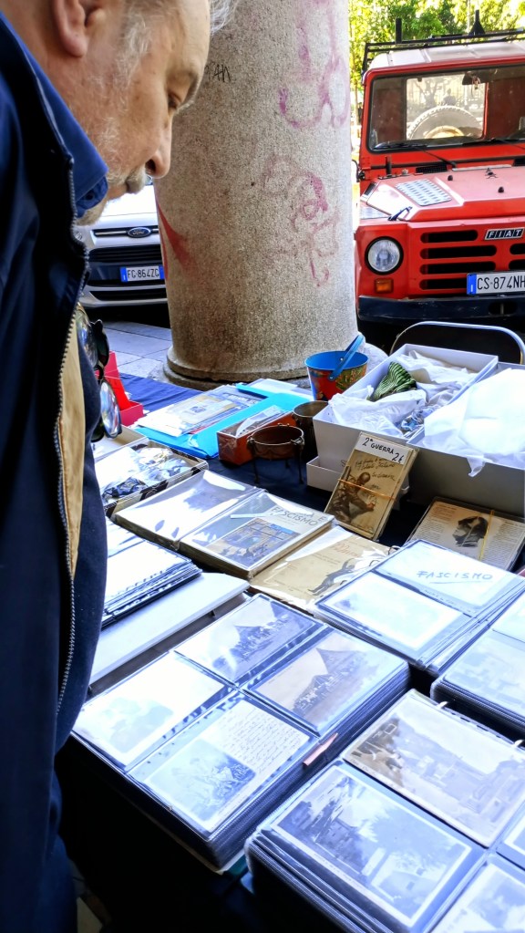 photo of Piazza Vittorio, man looking at postcards