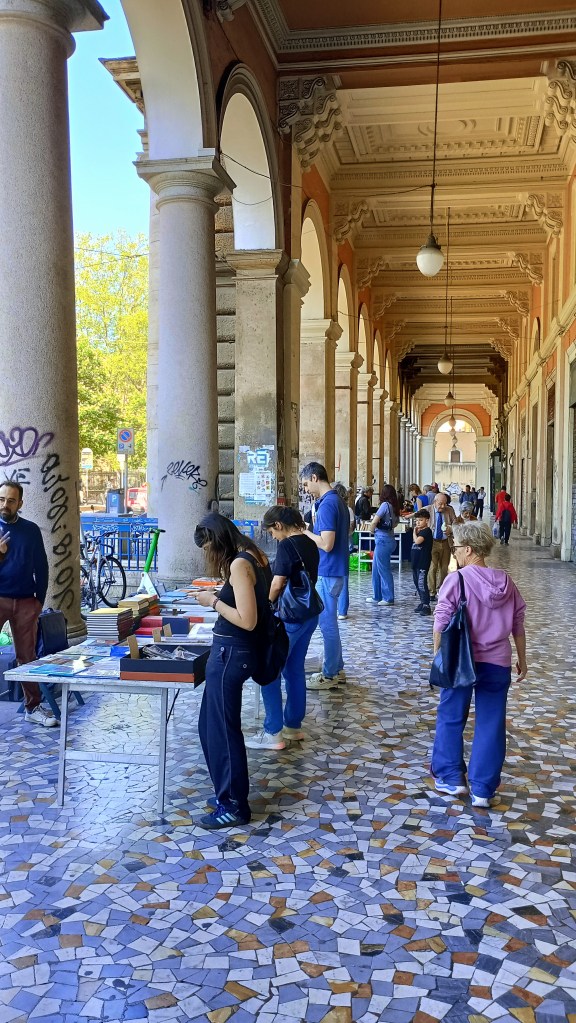 photo of Piazza Vittorio, portico with book market and people looking at books