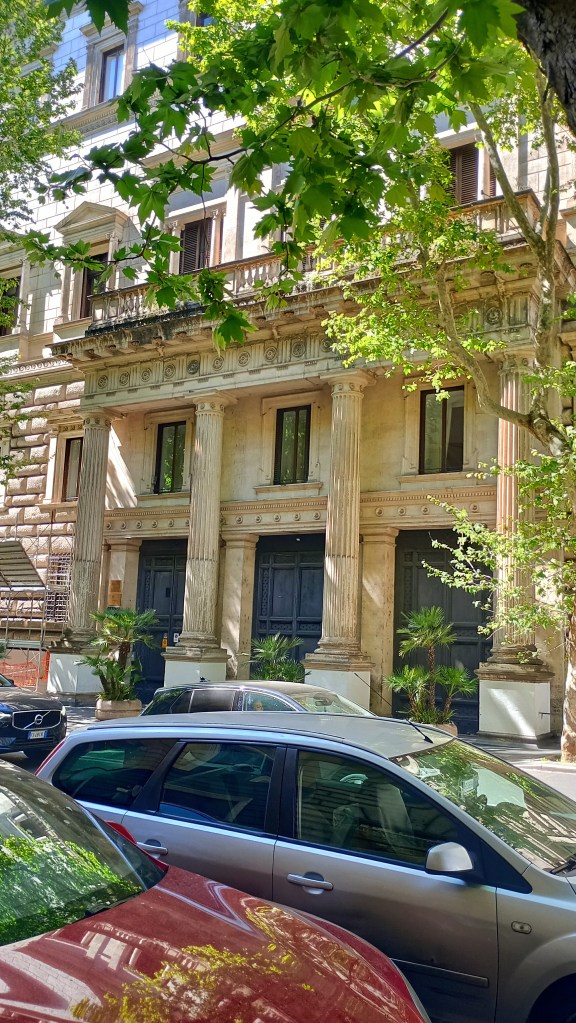 facade of Palazzo Brancaccio with cars and trees